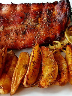 Una foto de Costilla a las finas hierbas con patatas gajo al horno