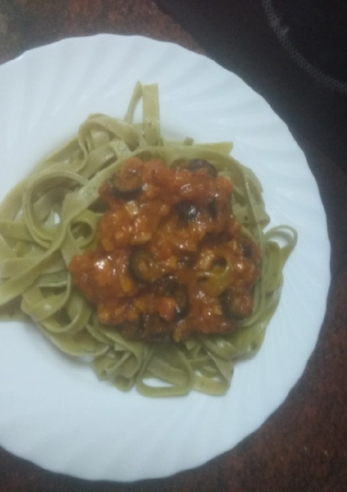 Una foto de Pasta verde con salsa de aceitunas negras y jamón cocido