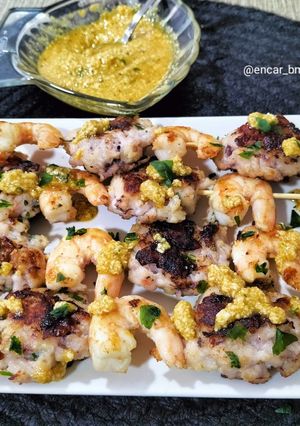 Una foto de Brocheta de langostinos y figatells de calamar con picadillo de almendra