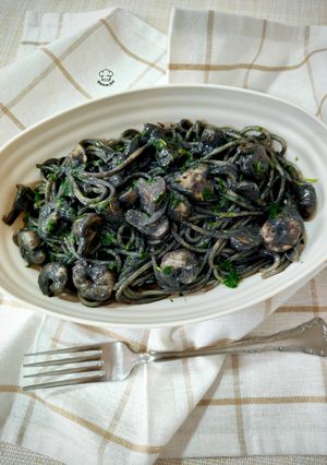 Una foto de Spaghetti cremoso con champiñón y gambas en tinta de calamar