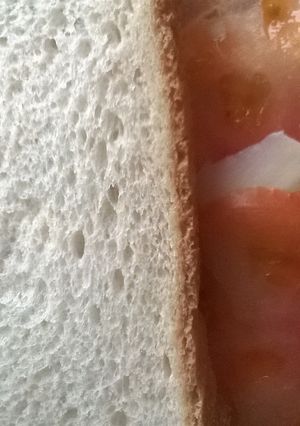 Una foto de Sándwich de pollo asado al limón con tomate, queso y salsa de miel y mostaza