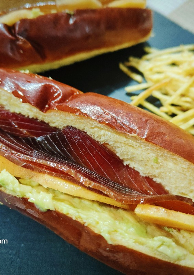 Una foto de Brioche de mojama con caqui y aguacate