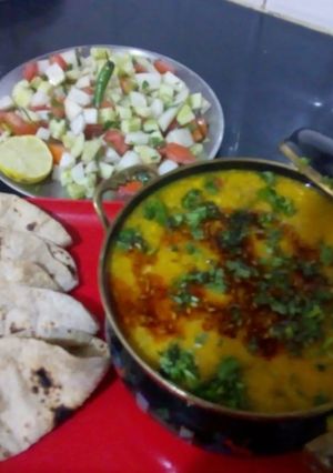 A picture of Punjabi dal tadka with salad and roti.