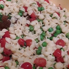 A picture of Pasta salad with peas and tomato.