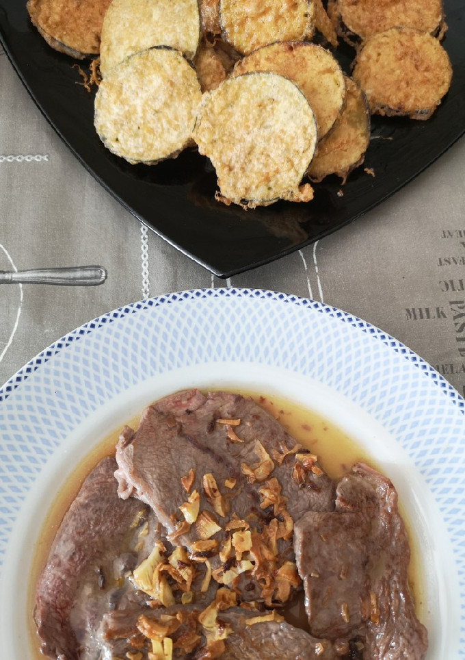 Una foto de Berenjenas rebozadas y filetes al ajillo