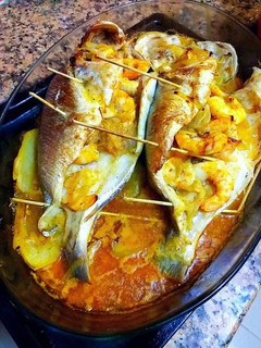 Una foto de Dorada al horno con langostinos macerados y patatas guisadas