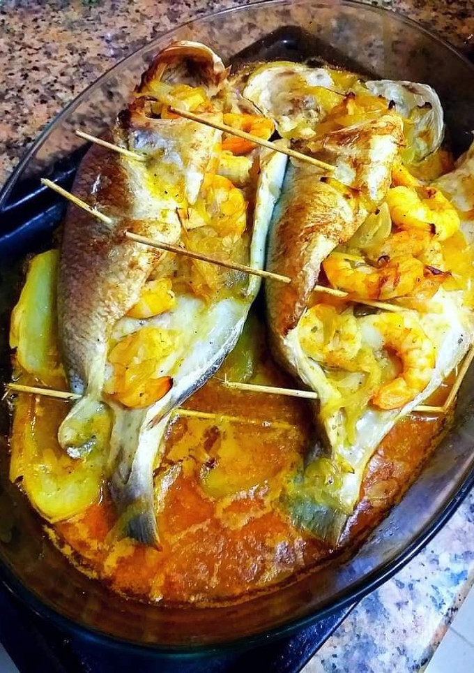 Una foto de Dorada al horno con langostinos macerados y patatas guisadas