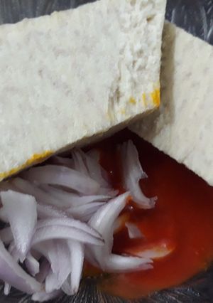 A picture of Boiled yam with red oil and onion.