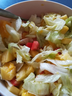 Una foto de Ensalada de lechuga, mango, piña con aderezo de naranja