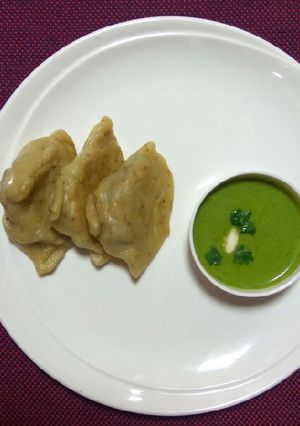 A picture of Steam samosa with yogurt mint sauce.