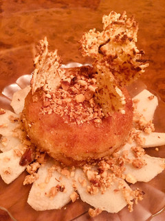 Una foto de Pincho de bola de patata con jamón ibérico, crujiente de queso y cama de pera gratinada