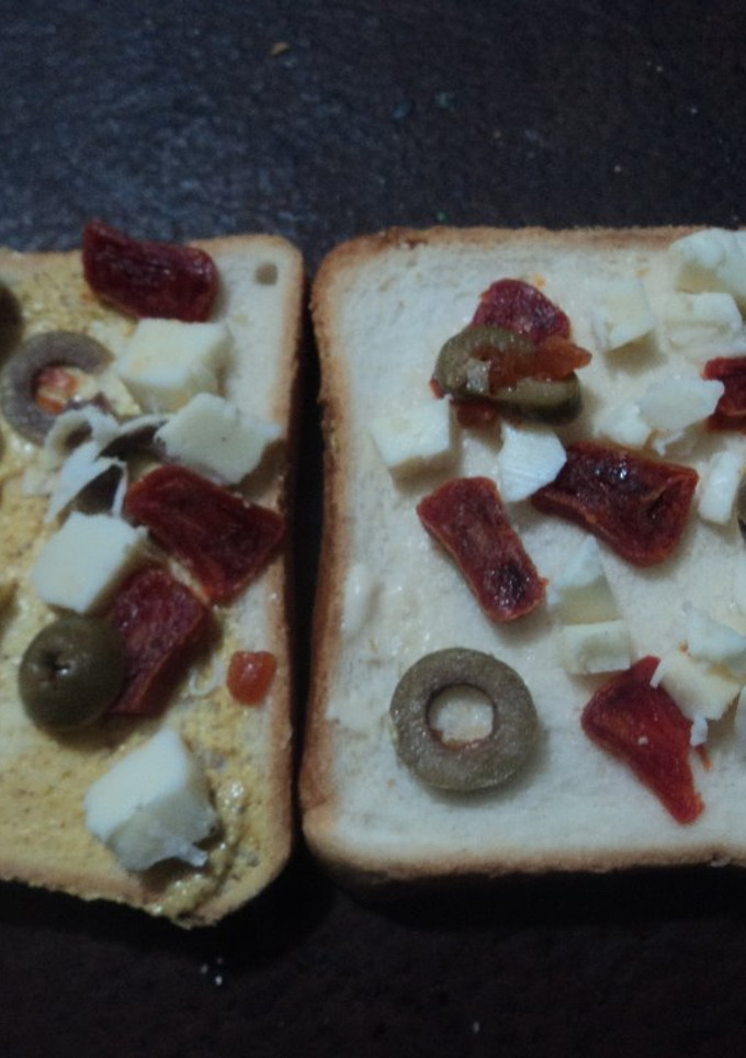 Una foto de Panes tostados con chistorra seca, aceitunas y queso fresco o panela