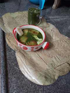 A picture of Spinach soup with bread croutons.