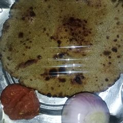 A picture of Bajra roti with lehsun chutney and pyaaz.