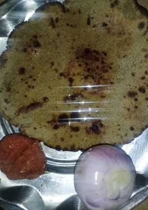 A picture of Bajra roti with lehsun chutney and pyaaz.