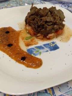 Una foto de Hígado encebollado sobre tartar de tomate