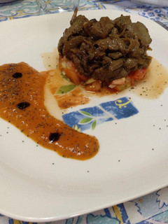 Una foto de Hígado encebollado sobre tartar de tomate