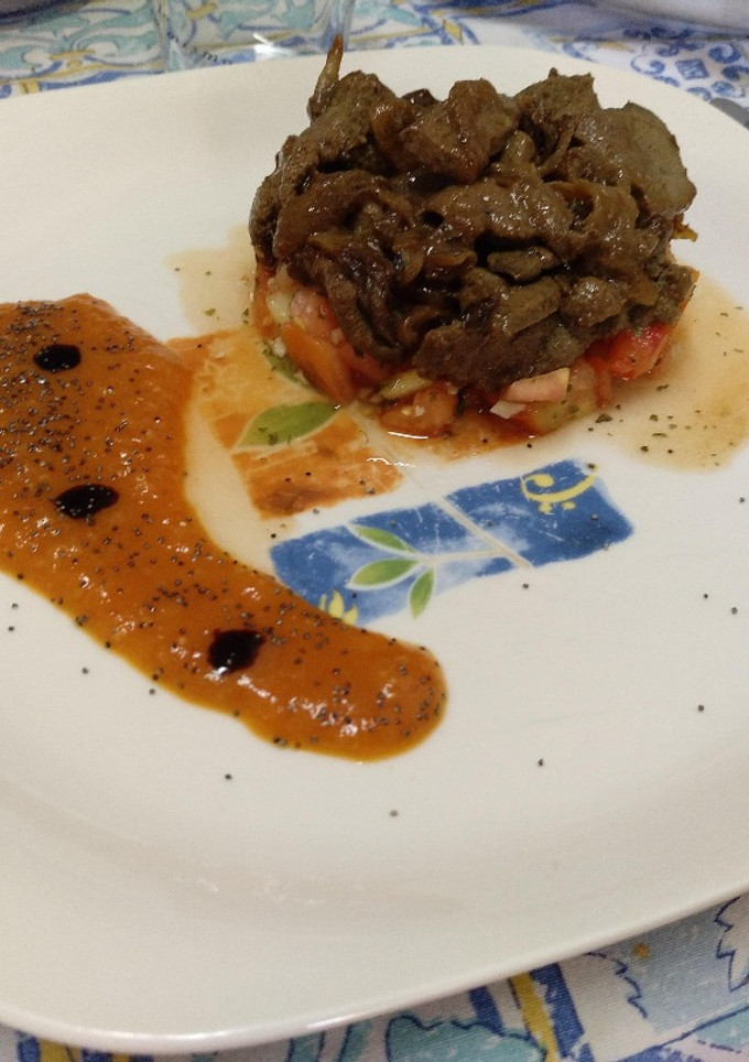 Una foto de Hígado encebollado sobre tartar de tomate