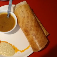 A picture of Masala dosa with vegeis sambhar.
