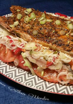 Una foto de Lomo de bonito con majado Urrutia al horno, sobre fondo de ensalada con boquerones en vinagre