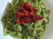 Una foto di pasta al pesto di rucola