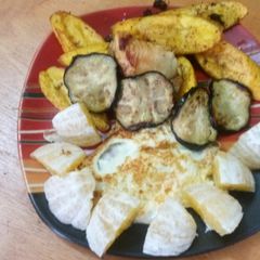 A picture of Fried plantain and eggs with orange and apple.