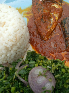 A picture of Rice, fish stew and veggie.