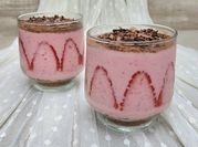Una foto de cheesecake de fresas en vaso