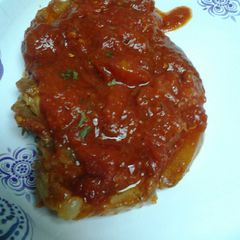 A picture of Stewed pork chops in a marinara sauce.