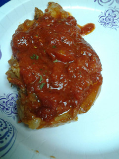 A picture of Stewed pork chops in a marinara sauce.