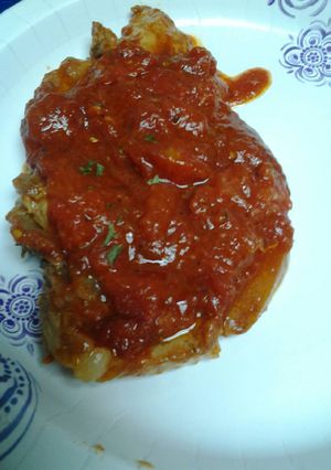 A picture of Stewed pork chops in a marinara sauce.
