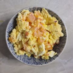 A picture of Scrambled eggs with tomato.