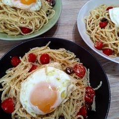 A picture of Spaghetti with eggs, tomatoes and olives.