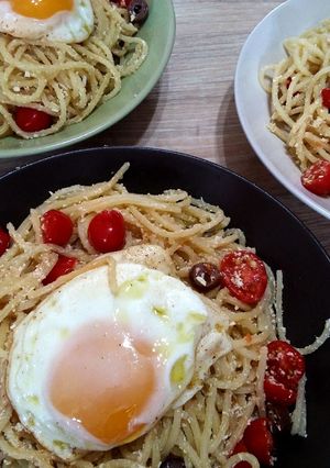 A picture of Spaghetti with eggs, tomatoes and olives.