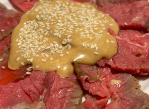 Foto di Carpaccio di lacerto marinato nella salsa teriyaki su salsa di maionese e okonomi e sesamo bianco