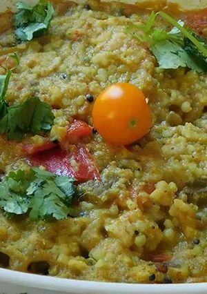 A picture of Drum stick tomato masala curry (sambar) mixed with rice.