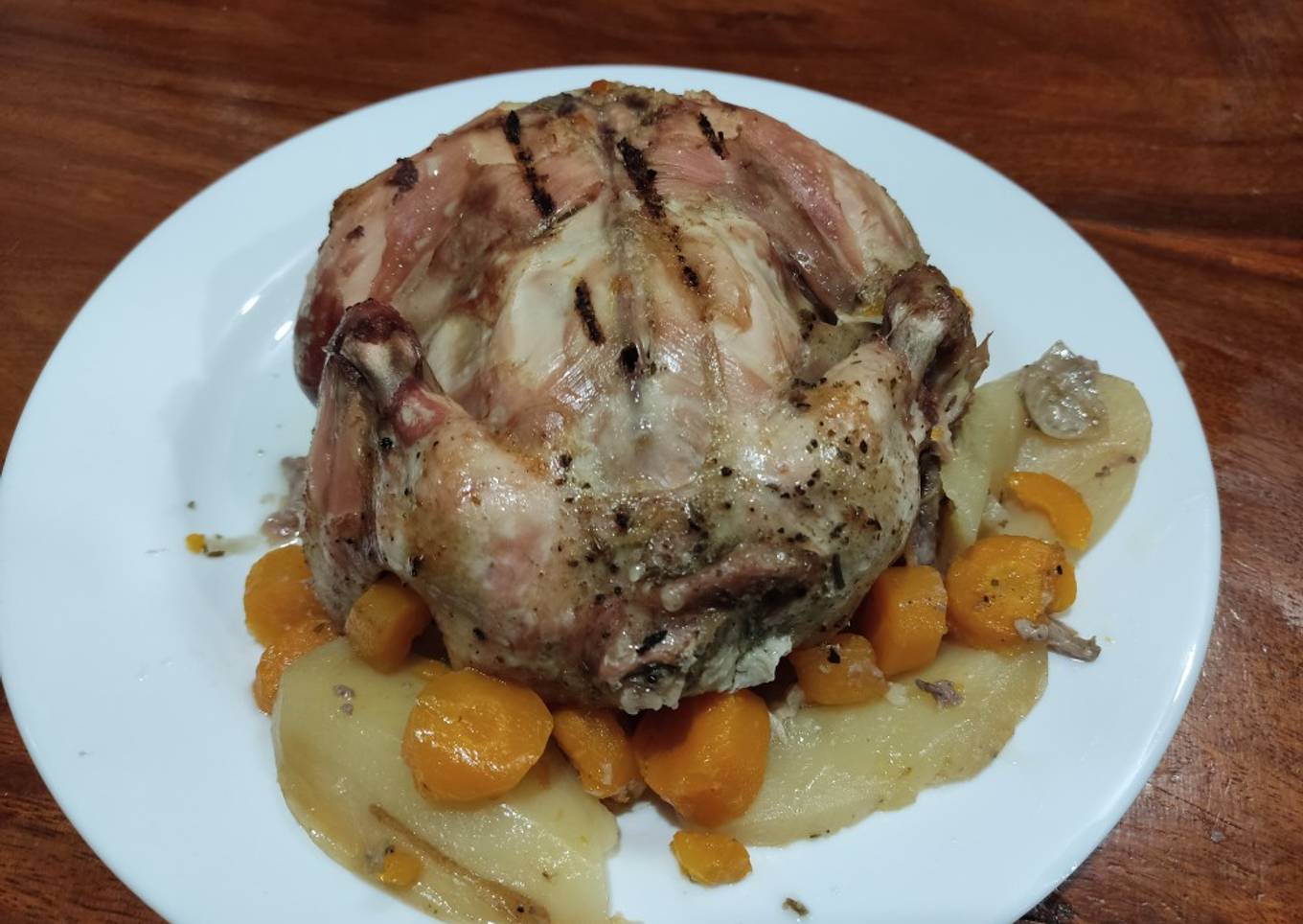 Pollo entero asado al carbón con papas y zanahoria