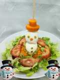 Hombrecillo de nieve en colchón de ensalada