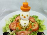 Hombrecillo de nieve en colchón de ensalada