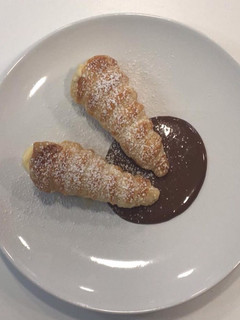 Una foto de Canutillos de crema con cama de chocolate