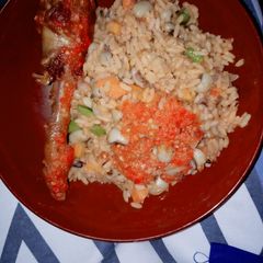 A picture of Jellof rice and beans with peppered chicken.