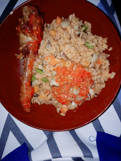 A picture of Jellof rice and beans with peppered chicken.