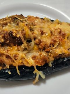 Una foto de Berenjenas rellenas de pollo, jamón y salchichas al horno
