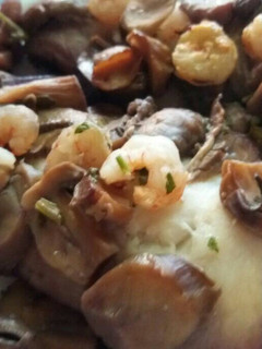 Una foto de Filete de merluza al horno con gambas y champiñones