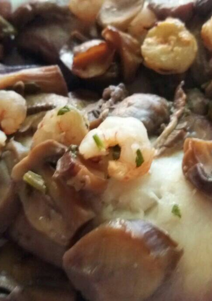 Una foto de Filete de merluza al horno con gambas y champiñones