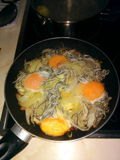 Una foto de Huevos estrellados con gulas, patatas y cebolla