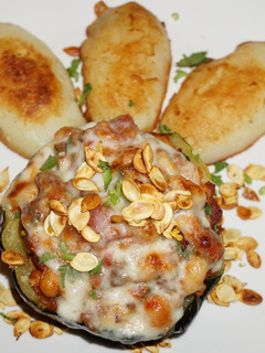 Una foto de Zapallo bellota relleno con cerdo y porotos blancos. Jon style
