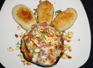 Una foto de Zapallo bellota relleno con cerdo y porotos blancos. Jon style