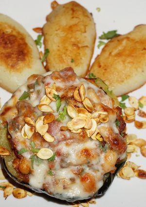 Una foto de Zapallo bellota relleno con cerdo y porotos blancos. Jon style