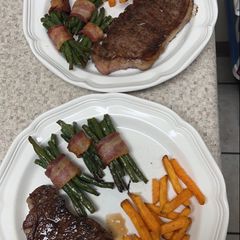 A picture of Steak with Bacon-Wrapped Green Beans and Sweet Potato Fries.
